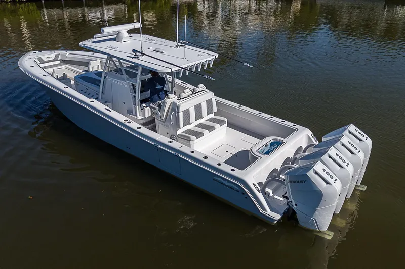  Yacht Photos Pics 2024 Invincible 39 Open Fisherman boat with triple outboard engines on calm water.