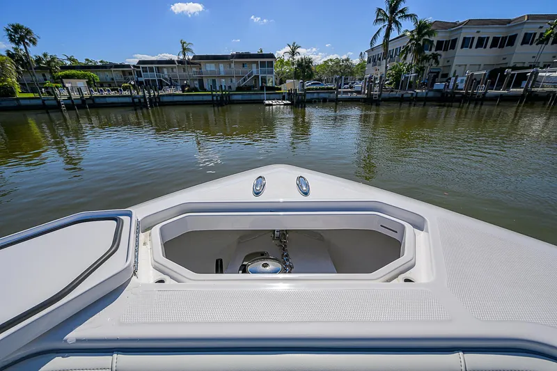  Yacht Photos Pics 2024 Invincible 39 Open Fisherman boat, bow view with anchor compartment, docked by waterfront homes.