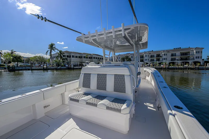  Yacht Photos Pics 2024 Invincible 39 Open Fisherman boat with seating, docked by waterfront homes.