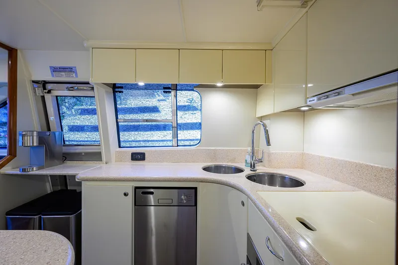Sea Hawk Yacht Photos Pics Modern kitchen in a 1997 Fairline Squadron yacht with dual sinks and stainless steel appliances.
