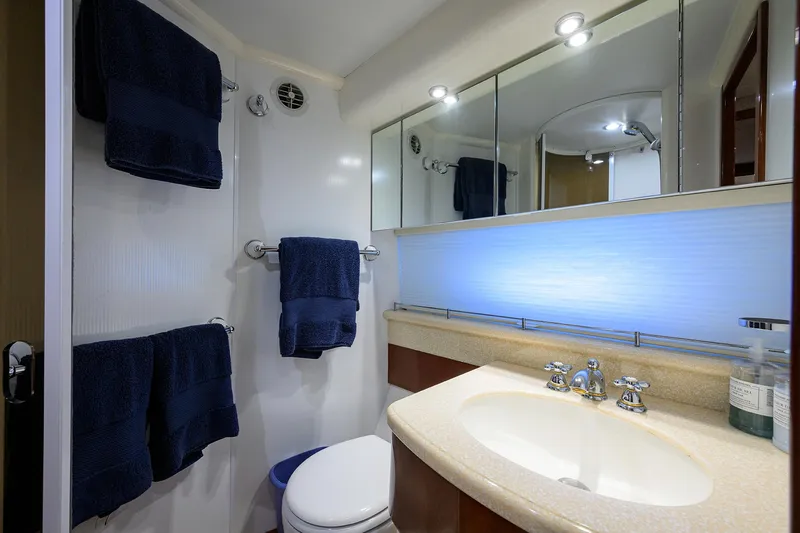 Sea Hawk Yacht Photos Pics 1997 Fairline Squadron yacht bathroom with sink, mirror, and blue towels.