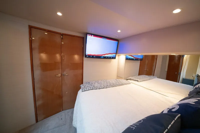  Yacht Photos Pics Luxurious bedroom interior of 2005 Viking 52 Convertible yacht with TV and elegant decor.