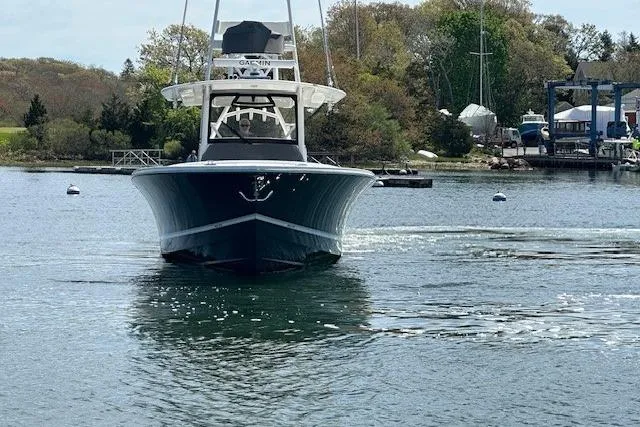  Yacht Photos Pics 2022 Regulator 41 boat on calm water, surrounded by trees and docks.