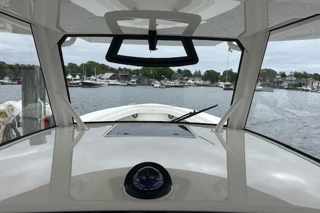  Yacht Photos Pics 2022 Regulator 41 boat cockpit view, overlooking marina with calm waters and docked boats.