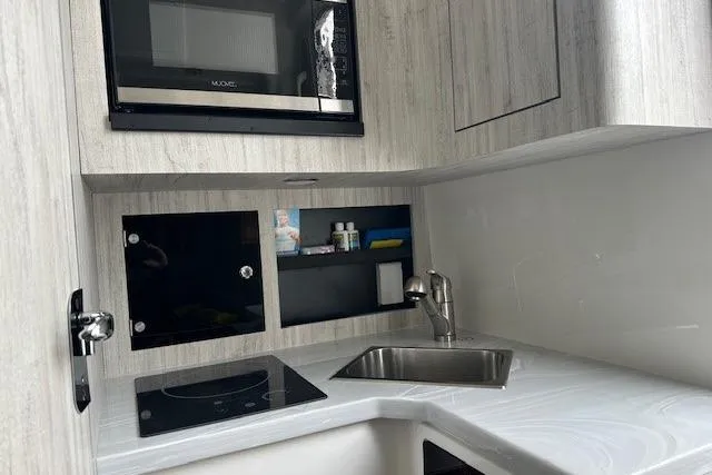  Yacht Photos Pics Modern kitchenette in 2022 Regulator 41 boat with sink, stove, and microwave.