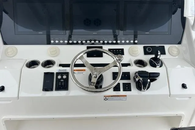  Yacht Photos Pics 2022 Regulator 41 boat dashboard with steering wheel and control panel.