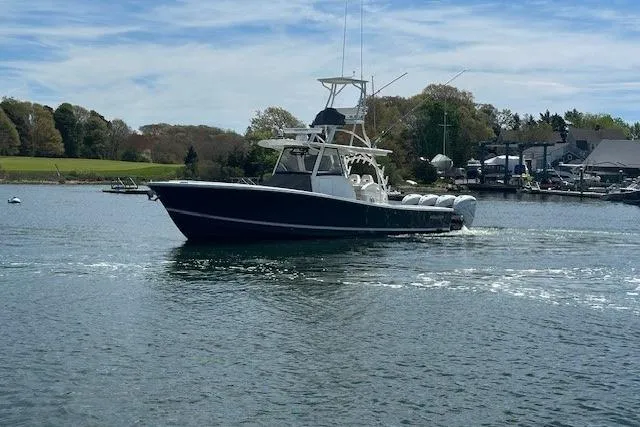  Yacht Photos Pics 2022 Regulator 41 boat cruising on a calm lake with scenic background.