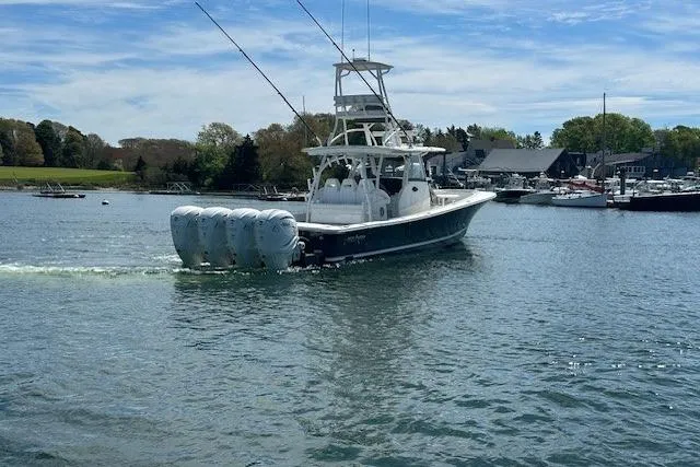  Yacht Photos Pics 2022 Regulator 41 boat with multiple engines cruising in a scenic harbor.