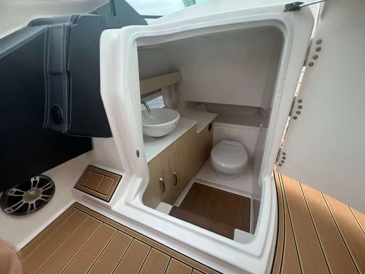  Yacht Photos Pics 2025 Regal 33 OBX boat interior with modern bathroom and wooden flooring.