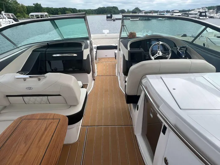 Yacht Photos Pics 2025 Regal 33 OBX boat interior with luxurious seating and modern dashboard on a serene lake.