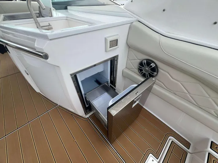  Yacht Photos Pics 2025 Regal 33 OBX boat interior with open drawer and speaker, featuring sleek design.