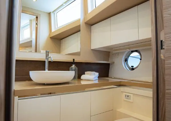  Yacht Photos Pics Modern bathroom interior on 2023 Greenline 45 Fly yacht, featuring sleek sink and porthole window.