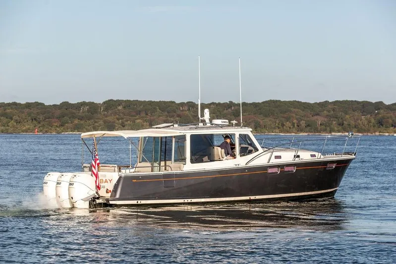 Goombay Yacht Photos Pics 2018 MJM 43z boat cruising on a lake with forested shoreline.