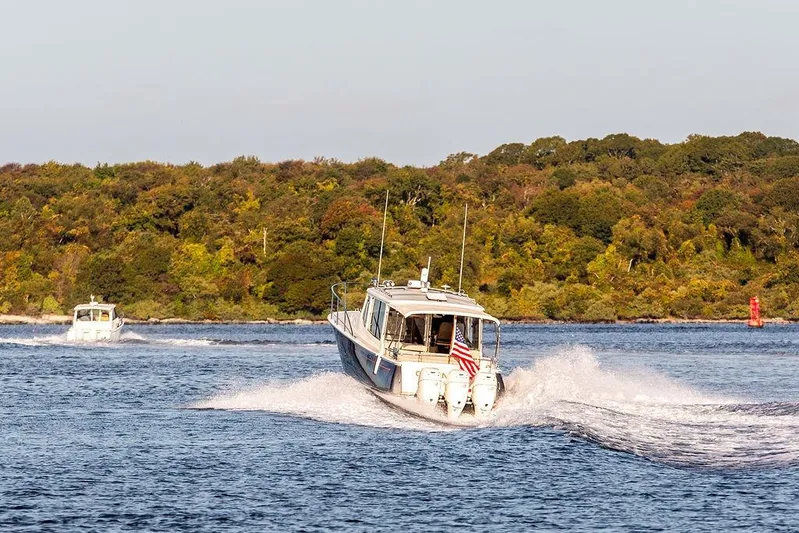 Goombay Yacht Photos Pics 2018 MJM 43z boat cruising on a scenic lake with lush green shoreline.