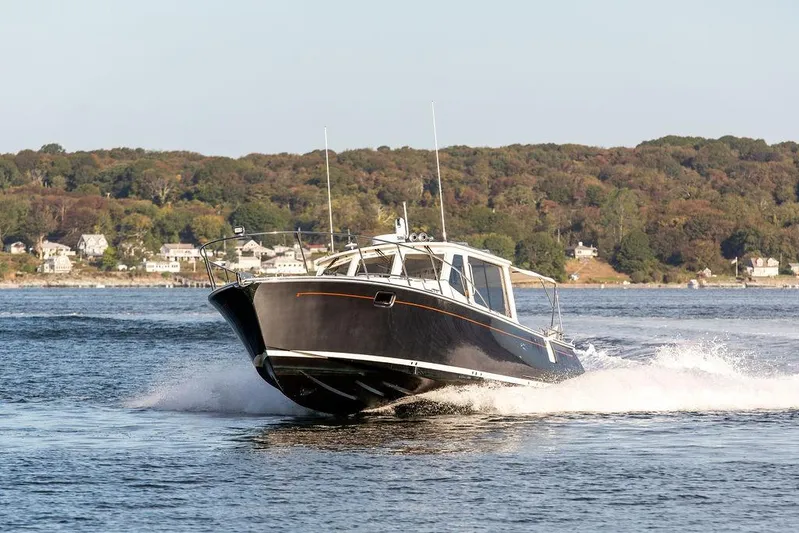 Goombay Yacht Photos Pics 2018 MJM 43z boat cruising on a scenic lake with forested shoreline.