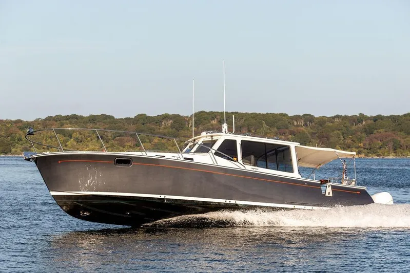 Goombay Yacht Photos Pics 2018 MJM 43z motor yacht cruising on a calm lake with forested shoreline.