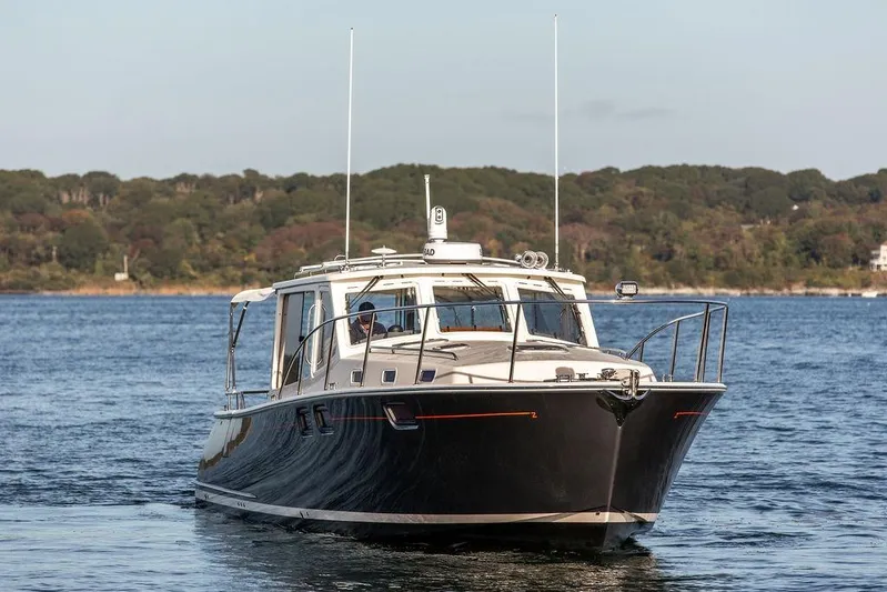 Goombay Yacht Photos Pics 2018 MJM 43z yacht cruising on a serene lake with forested shoreline.