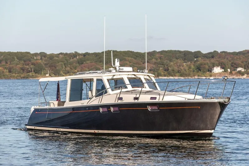 Goombay Yacht Photos Pics 2018 MJM 43z yacht cruising on a serene lake with forested shoreline.