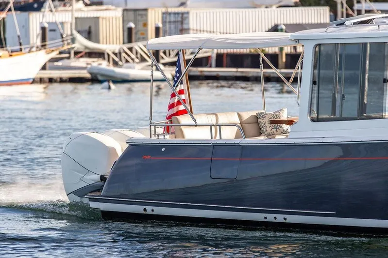 Goombay Yacht Photos Pics 2018 MJM 43z boat cruising with American flag, dockside background.