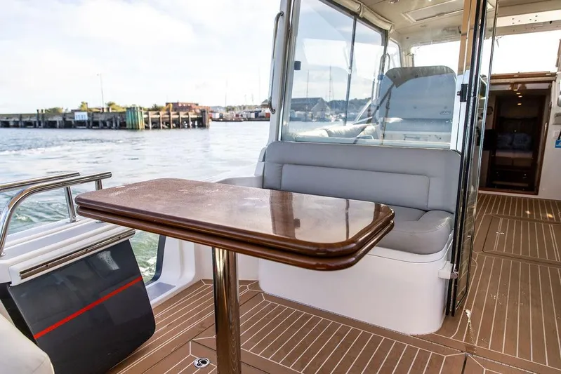 Goombay Yacht Photos Pics Interior view of 2018 MJM 43z yacht with seating and wooden table.