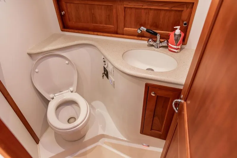 Goombay Yacht Photos Pics 2018 MJM 43z yacht bathroom with toilet, sink, and wooden cabinetry.