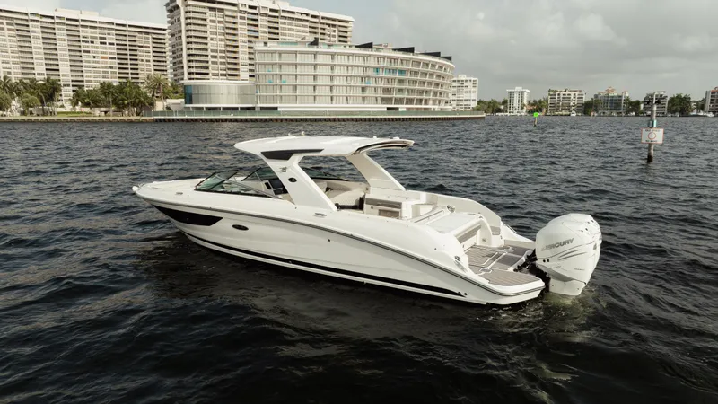  Yacht Photos Pics 2023 Sea Ray 350 Sundancer boat on water near modern buildings.