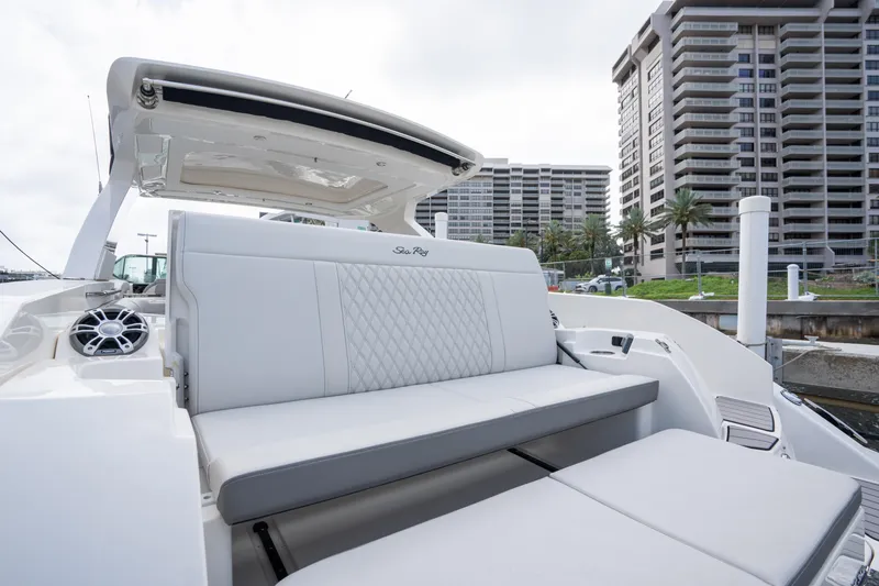  Yacht Photos Pics 2023 Sea Ray 350 Sundancer luxury boat interior with plush seating, docked near modern buildings.
