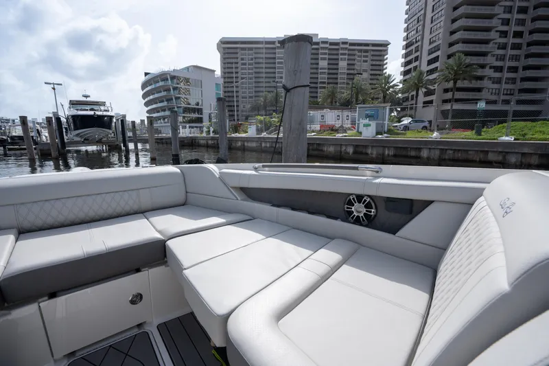  Yacht Photos Pics Luxurious seating on 2023 Sea Ray 350 Sundancer yacht at marina, with modern buildings in background.