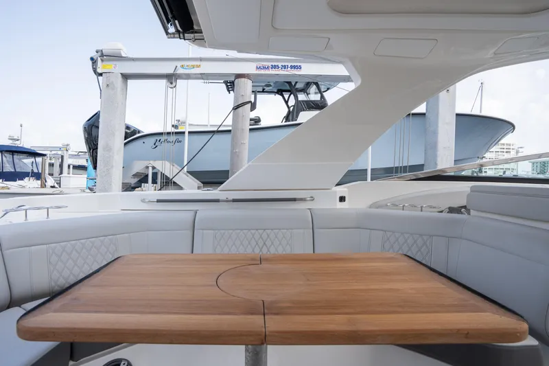  Yacht Photos Pics 2023 Sea Ray 350 Sundancer interior with wooden table and cushioned seating.