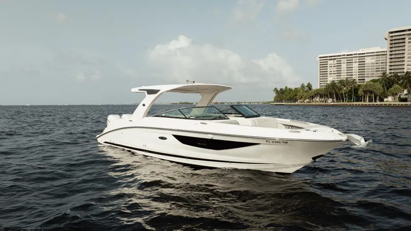  Yacht Photos Pics 2023 Sea Ray 350 Sundancer boat on water near city skyline.