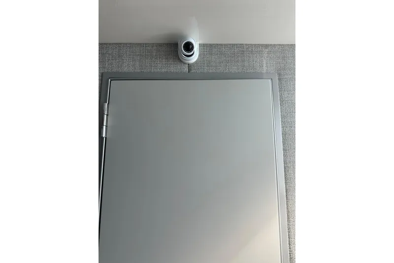  Yacht Photos Pics Security camera above a closed door on a textured wall.