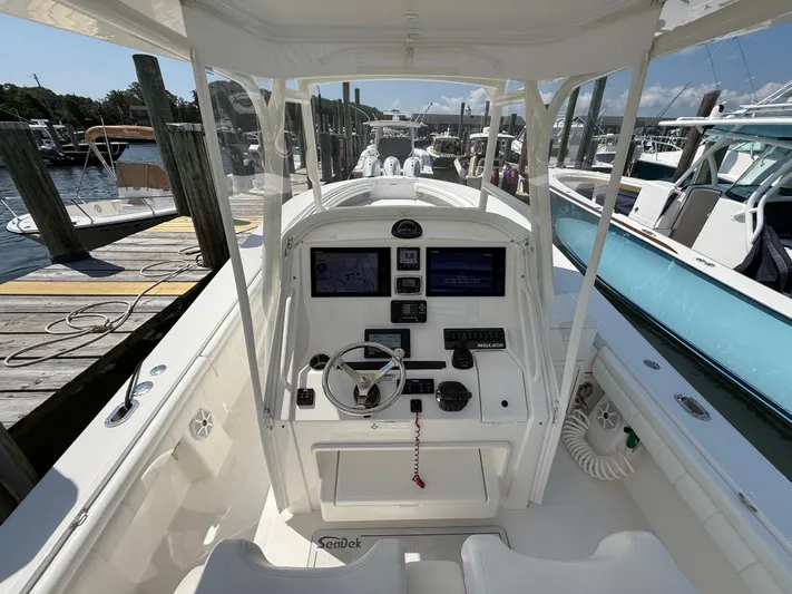 Tiger Yacht Photos Pics 2017 Regulator 34SS boat cockpit with modern navigation equipment at a marina.