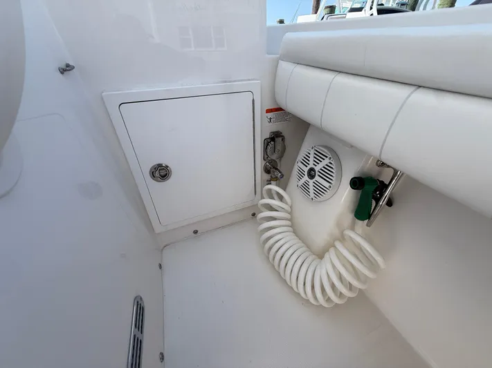 Tiger Yacht Photos Pics 2017 Regulator 34SS boat interior with storage compartment, speaker, and coiled hose.