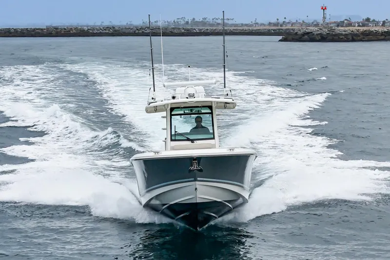  Yacht Photos Pics 2019 Boston Whaler 330 Outrage cruising on open water, creating a dynamic wake.