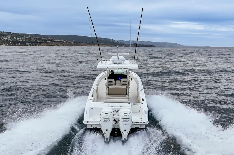  Yacht Photos Pics 2019 Boston Whaler 330 Outrage cruising on open water, rear view.