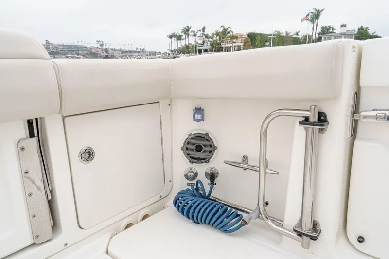  Yacht Photos Pics 2019 Boston Whaler 330 Outrage boat interior with storage, speaker, and coiled hose.