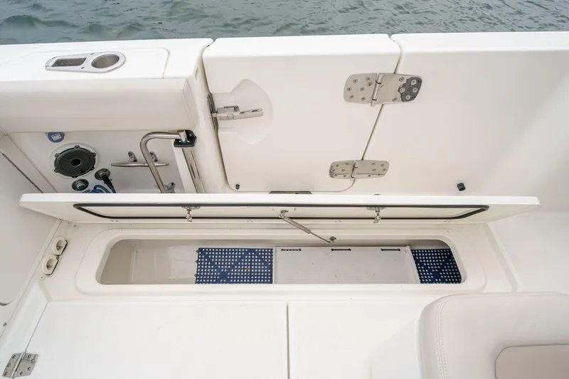  Yacht Photos Pics 2019 Boston Whaler 330 Outrage boat storage compartment with open hatch, showcasing interior details.