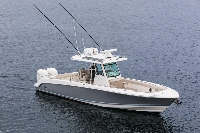  Yacht Photos Pics 2019 Boston Whaler 330 Outrage boat on calm water, featuring dual engines and fishing rods.