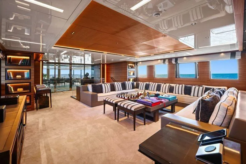 Magna Grecia Yacht Photos Pics Luxurious yacht interior with striped seating, ocean view, and elegant wooden accents, Elsflether Werft AG 1986.