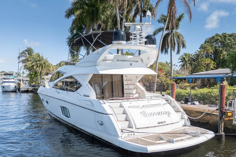Currency Yacht Photos Pics 2009 Sunseeker Manhattan 60 yacht docked by palm trees, sunny day.