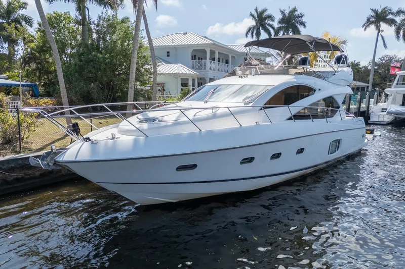 Currency Yacht Photos Pics Luxury 2009 Sunseeker Manhattan 60 yacht docked near palm trees and waterfront homes.