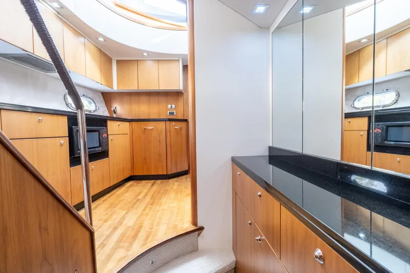 Currency Yacht Photos Pics Luxurious kitchen interior of 2009 Sunseeker Manhattan 60 yacht with wood cabinetry and modern appliances.