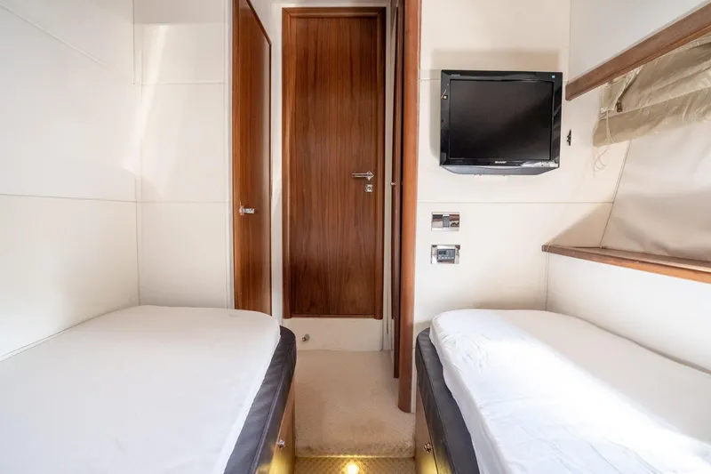 Currency Yacht Photos Pics Twin cabin interior of 2009 Sunseeker Manhattan 60 yacht with TV and wooden accents.