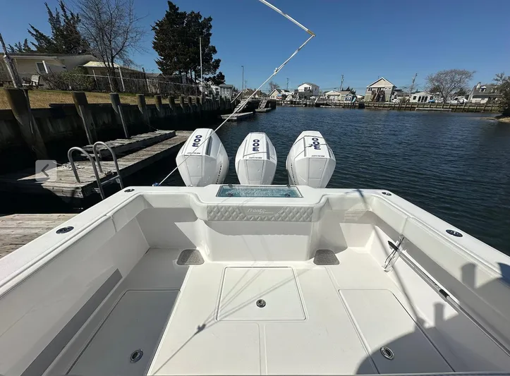 Avery Ann Yacht Photos Pics 2023 Front Runner 33 Center Console boat with triple outboard engines docked by a canal.