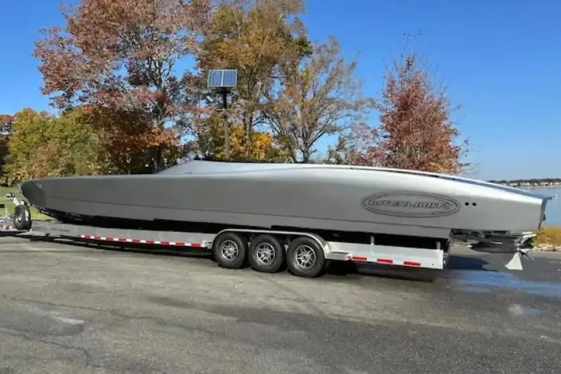  Yacht Photos Pics 2020 Outerlimits SL-50 powerboat on trailer, surrounded by autumn trees.
