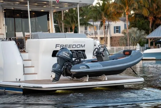 Freedom Yacht Photos Pics 2022 Sirena 58 Flybridge yacht with a small boat on the swim platform.