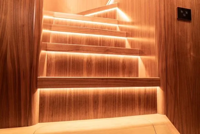 Freedom Yacht Photos Pics Luxurious wooden staircase with ambient lighting on a 2022 Sirena 58 Flybridge yacht.