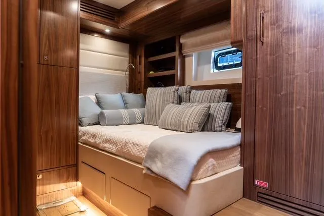 Freedom Yacht Photos Pics Luxurious cabin interior of 2022 Sirena 58 Flybridge yacht with cozy bedding and wooden finishes.