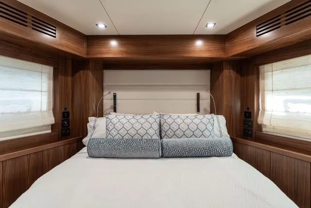 Freedom Yacht Photos Pics Luxurious bedroom interior of 2022 Sirena 58 Flybridge yacht with elegant wood paneling.