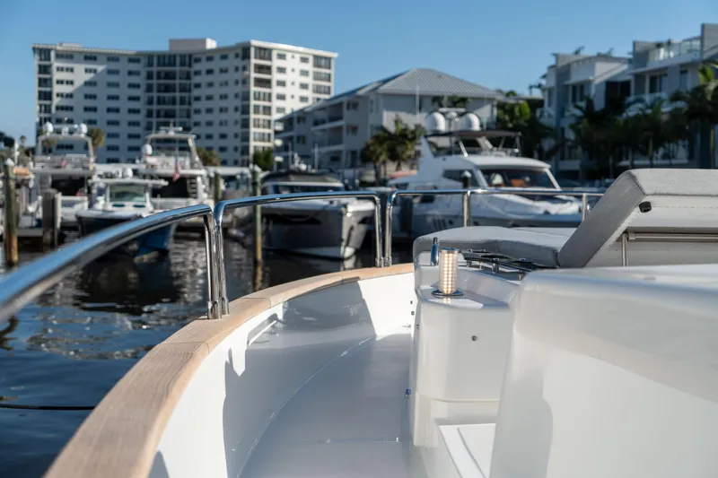 Freedom Yacht Photos Pics 2022 Sirena 58 Flybridge yacht docked in a marina with modern buildings.